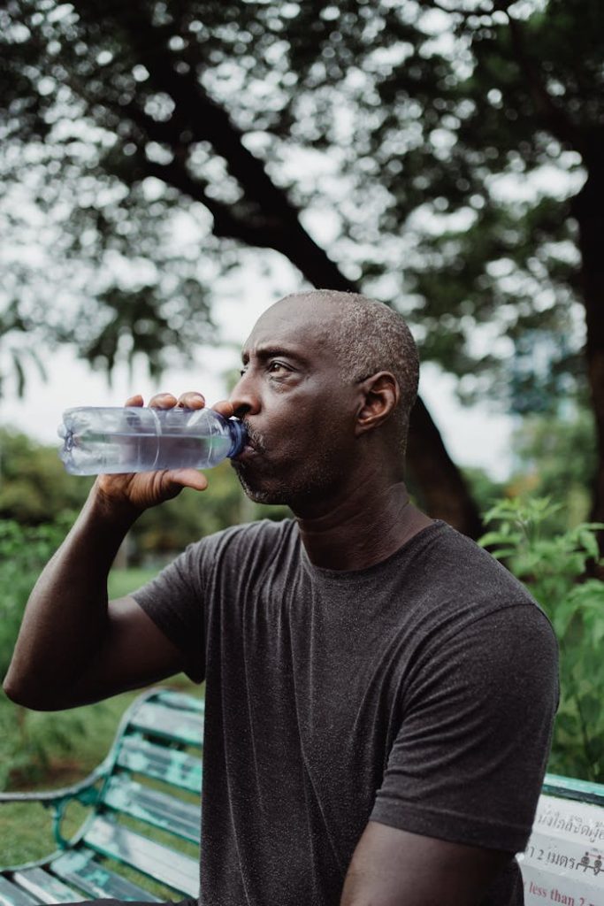 Man in Black Crew Neck T-shirt Drinking Water